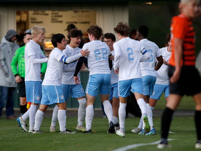 Lansing Catholic players celebrate with Eli Kluemper (22) after his goal against Alma, Tuesday, Oct. 21, 2025, at Williamston High School.