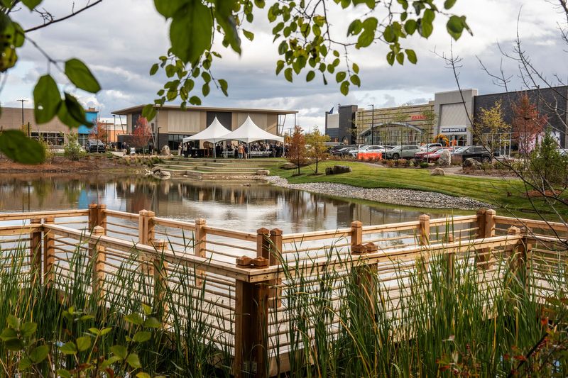 A floating bridge is seen along a pond near businesses before the start of a dedication for the Sakura Gardens at the center of the Sakura Novi development in Novi on Thursday, October 23, 2025.