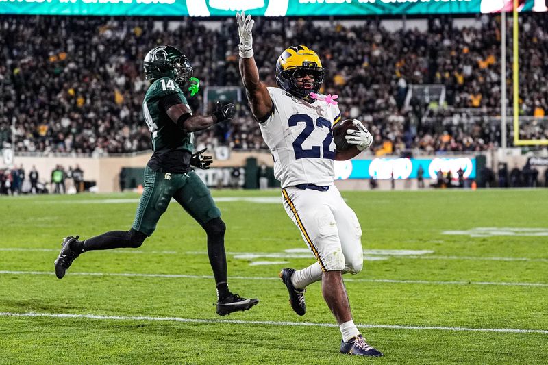 Michigan running back Justice Haynes (22) runs for a touchdown against Michigan State defensive back Malcolm Bell (14) during the second half at Spartan Stadium in East Lansing on Saturday, October 25, 2025.