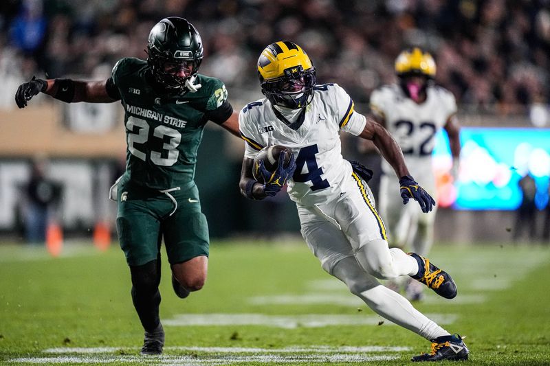 Michigan wide receiver Andrew Marsh (4) runs against Michigan State linebacker Darius Snow (23) during the second half at Spartan Stadium in East Lansing on Saturday, October 25, 2025.