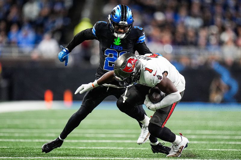Detroit Lions cornerback Amik Robertson (21) tackles Tampa Bay Buccaneers running back Rachaad White (1) during the second half at Ford Field in Detroit on Monday, Oct. 20, 2025.