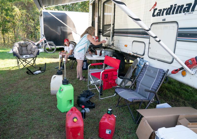 Kristi Bondeson, of Middleville, an organizer for the Mid-Michigan Trials Club stirs her carnitas to contribute to a big fiesta dinner party hosted by the organization in Vermontville on Saturday, Sept. 27, 2025. Her camp site looks like many competition sites with multiple gas cans, chairs, and motorcycles. The two-day event featured a vintage trials bike competition, kids ride, live music and the main event, a rider competition for varying skill levels that include expert, advanced, sportsman, senior A, intermediate, senior B, novice, beginner, and youth.