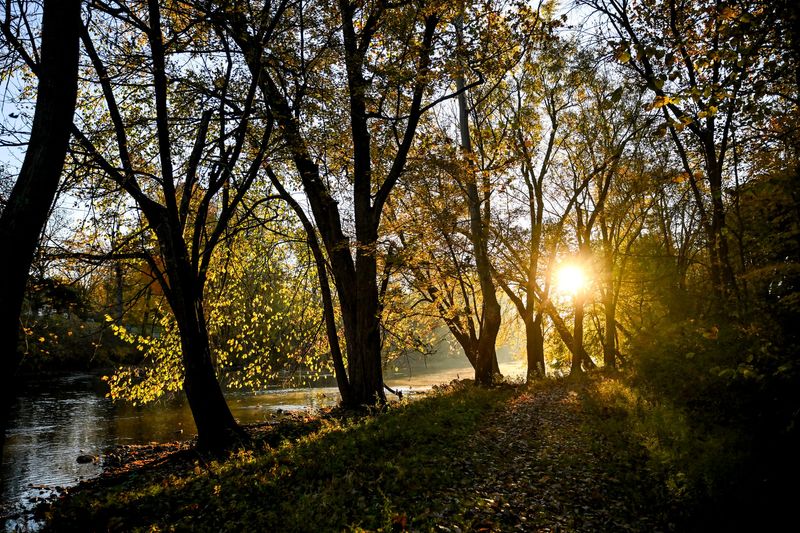 The sun rises above the Grand River at Thomas F. Keegan Nature Park on Tuesday, Oct. 28, 2025, in Lansing Township.