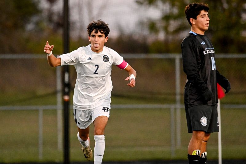 Detroit Country Day's Tino Haratsaris, left, celebrates his goal as Lansing Catholic's Santi Contreras stands by during the first half on Wednesday, Oct. 29, 2025, in the D3 state semifinal at Howell Parker Middle School.