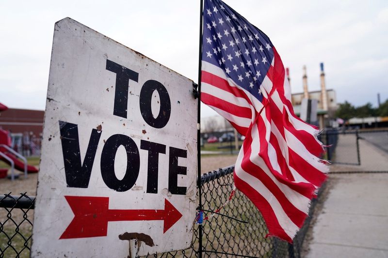 A sign to vote with the American flag attached directs voters to Salina Intermediate School in Dearborn so they can cast their vote during the presidential primary on Tuesday, Feb. 27, 2024.