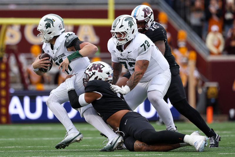 Nov 1, 2025; Minneapolis, Minnesota, USA; Minnesota Golden Gophers defensive lineman Anthony Smith (0) tackles Michigan State Spartans quarterback Alessio Milivojevic (11) during the first half at Huntington Bank Stadium. Mandatory Credit: Matt Krohn-Imagn Images