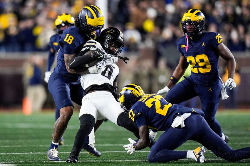 Michigan linebacker Troy Bowles (18) tackles Purdue wide receiver Nitro Tuggle (0) during the first half at Michigan Stadium in Ann Arbor on Saturday, November 1, 2025.
