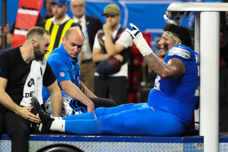 Nov 2, 2025; Detroit, Michigan, USA; Detroit Lions offensive lineman Christian Mahogany (73) is helped off the field after an injury in the fourth quarter against the Minnesota Vikings at Ford Field.