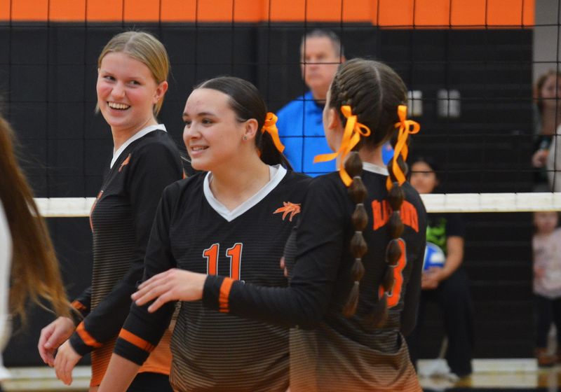 Fennville's Brooklyn Gardea, left, MacKenzie McIlwain and Ceeley Howard celebrate a point during the Division 3 district quarterfinals on Monday, Nov. 3, 2025, at Fennville High School.