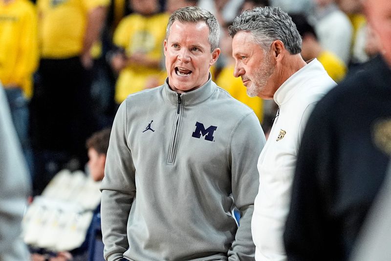 Michigan head coach Dusty May, left, talks to Oakland head coach Greg Kampe before tipoff at Crisler Center in Ann Arbor on Monday, November 3, 2025.