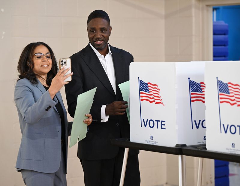 Robin Kinloch, left, wife of Detroit mayoral candidate Solomon Kinolch, takes a selfie after he finished casting his ballot in precinct 123 at Chrysler Elementary School on Nov. 4, 2025, in Detroit. Michigan has rules about what kind of photos can be taken at polling places.