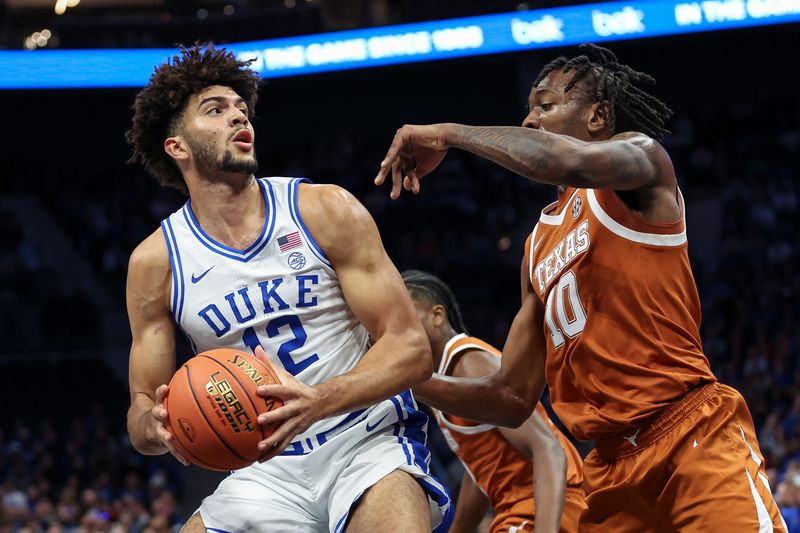 Duke Blue Devils forward Cameron Boozer (12) battles for position against Texas Longhorns forward Nic Codie (10) during the first quarter at the Dick Vitale’s Invitational game at Spectrum Center.