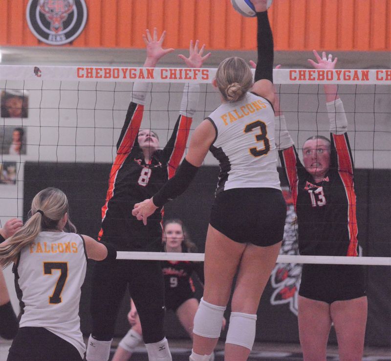 Cheboygan seniors Olivia Patrick (8) and Tessa Lake (13) attempt to block an attack against Ogemaw Heights sophomore Kendel Morris (3) during the first set of an MHSAA Division 2 district volleyball final at Cheboygan on Thursday, Nov. 6.