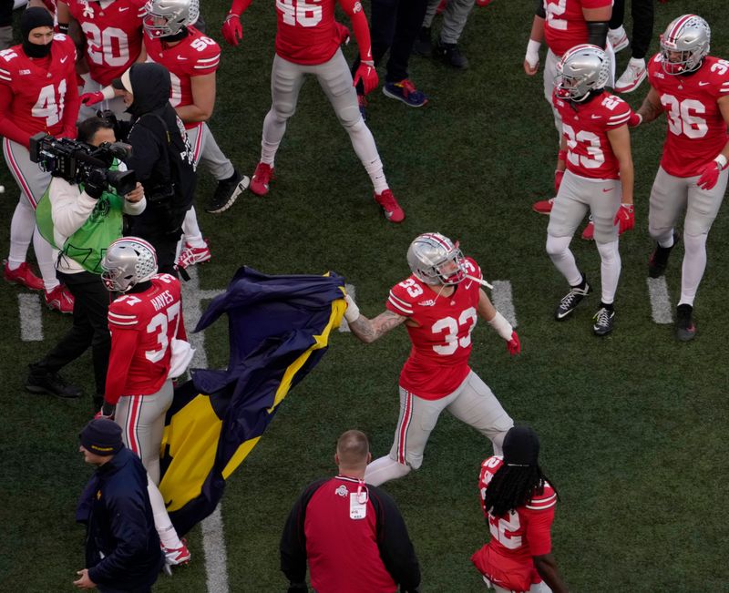 Ohio State Buckeyes defensive end Jack Sawyer (33) throws a Michigan flag take from opposing players at midfield following Saturdayâ€™s NCAA Division I at Ohio Stadium, a 13-10 win for the Wolverines.