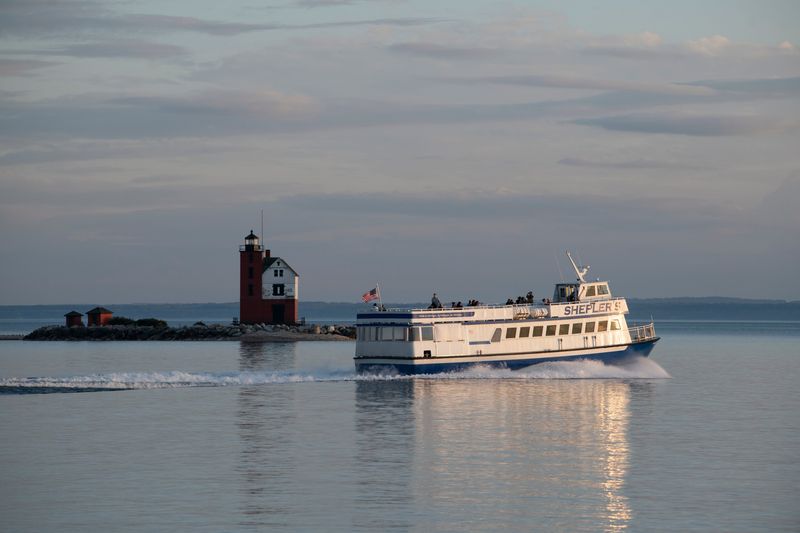 A Shepler’s ferry cruises past the Round Island Lighthouse in the Straits of Mackinac near Mackinac Island. The company that operates Shepler's and Arnold Transit Co. ferries is threatening to halt service next year if it can't reach agreement with the city on a lease renewal.