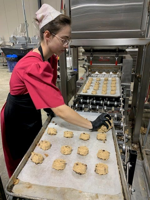 Lisa Wickey manages dough for what will eventually be oatmeal raisin cookies Nov. 11 at Yoder’s Baking Company in Centreville.