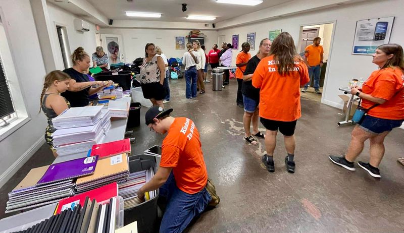 Volunteers wearing “Kindness in Action” shirts assemble backpacks and school supplies during Kind Human 4 Human Kind’s Back to School event Aug. 23, 2025, at Paul Mitchell The School in Port Huron.