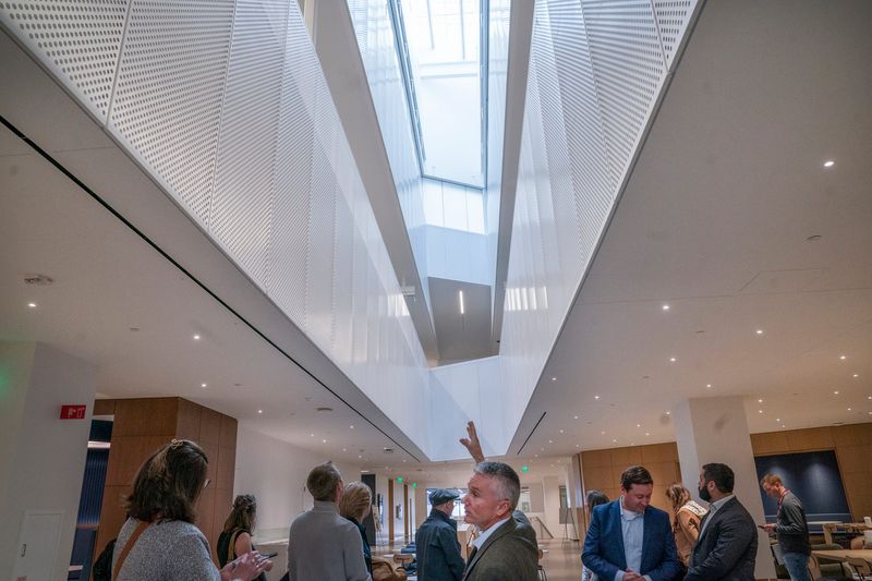 Jim Dobleske, CEO of Ford Land, center, discusses an elongated skylight that is visible from the second floor Great Lakes Courtyard area in new Ford World Headquarters on Monday, Nov. 10, 2025.