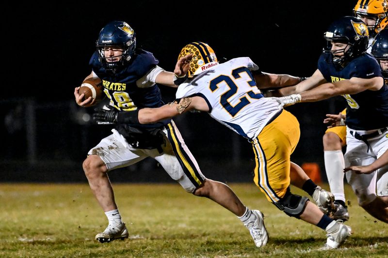 Pewamo-Westphalia's Ty Thelen, left, runs the ball as Ithaca's Jacob Crawford closes in during the first quarter on Friday, Nov. 14, 2025, at Pewamo-Westphalia High School.
