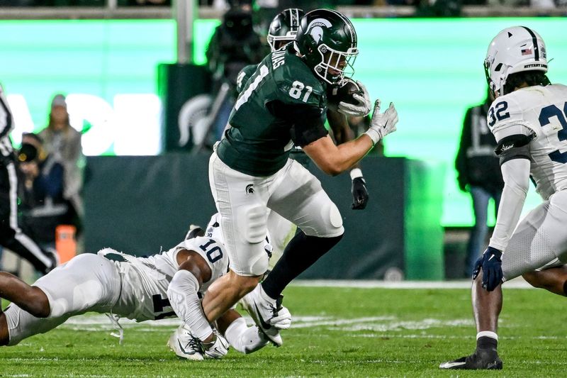 Michigan State's Michael Masunas catches a pass as Penn State's Dejuan Lane, left, attempts the tackle during the third quarter on Saturday, Nov. 15, 2025, at Spartan Stadium in East Lansing.