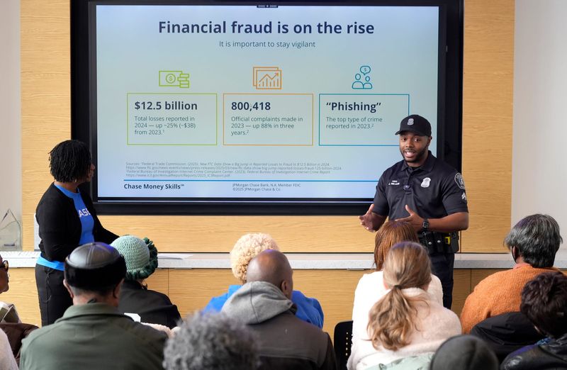 Gail Taylor, the Detroit Community Manager for Chase Bank, left, listens as Jalon Nelson of the Detroit Police Department, speaks to a senior citizen community group about various scams to be aware of during a workshop at the Corktown Community Center on Michigan Avenue in Detroit on Tuesday, Nov. 18, 2025.