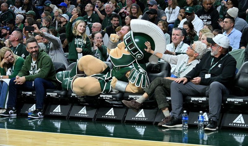 Nov 21, 2025; East Lansing, Michigan, USA; Michigan State mascot ÒPartyÓ lounges in the high-priced seats during a break in the action against the Detroit Mercy Titans at Jack Breslin Student Events Center. Mandatory Credit: Dale Young-Imagn Images