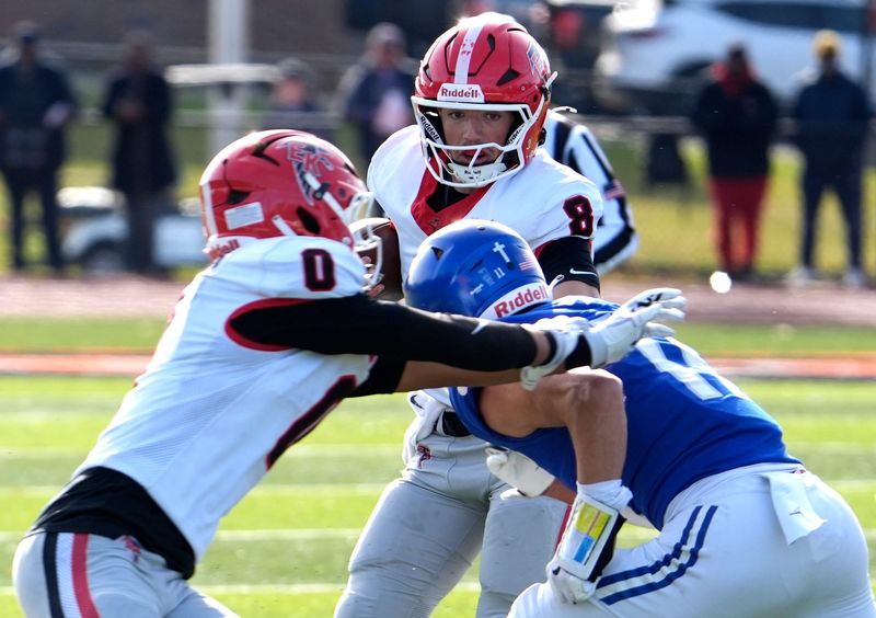East Kentwood quarterback (8) Kayd Coffman gets pressured by the defense of Novi Detroit Catholic Central (11) Gideon Gash during the first half of the MHSAA Division 1 football semifinals between Novi Detroit Catholic Central and East Kentwood at Jackson High School in Jackson on Saturday, Nov. 22, 2025.