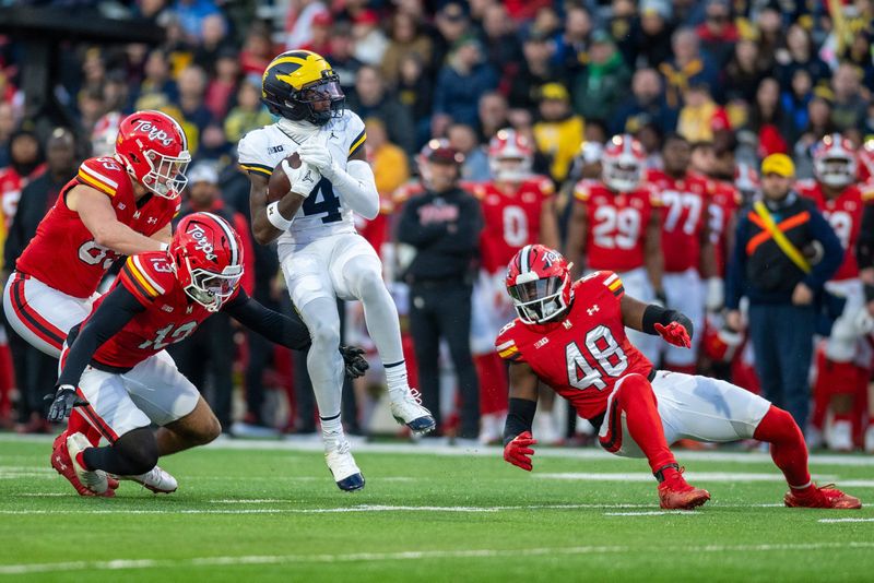 Michigan Wolverines wide receiver Andrew Marsh (4) spins on a punt return in-between Maryland Terrapins defenders during the first half at SECU Stadium in College Park, Maryland on Saturday, Nov. 22, 2025.