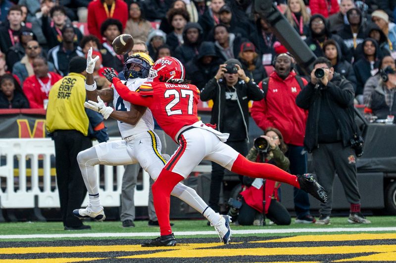 Nov 22, 2025; College Park, Maryland, USA; Michigan Wolverines wide receiver Andrew Marsh (4) catches a pass for a touchdown as Maryland Terrapins defensive back La'Khi Roland (27) defends during the first quarter at SECU Stadium. Mandatory Credit: Tommy Gilligan-Imagn Images