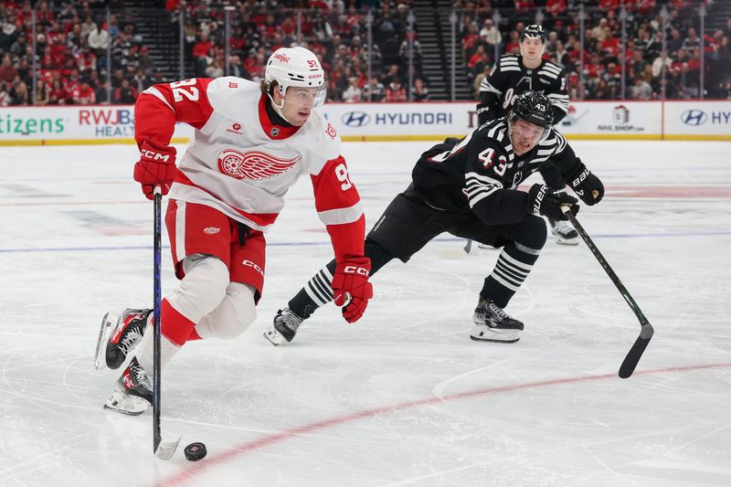 Detroit Red Wings center Marco Kasper (92) skates with the puck as New Jersey Devils defenseman Luke Hughes (43) defends during the first period at Prudential Center in Newark, New Jersey, on Monday, Nov. 24, 2025.