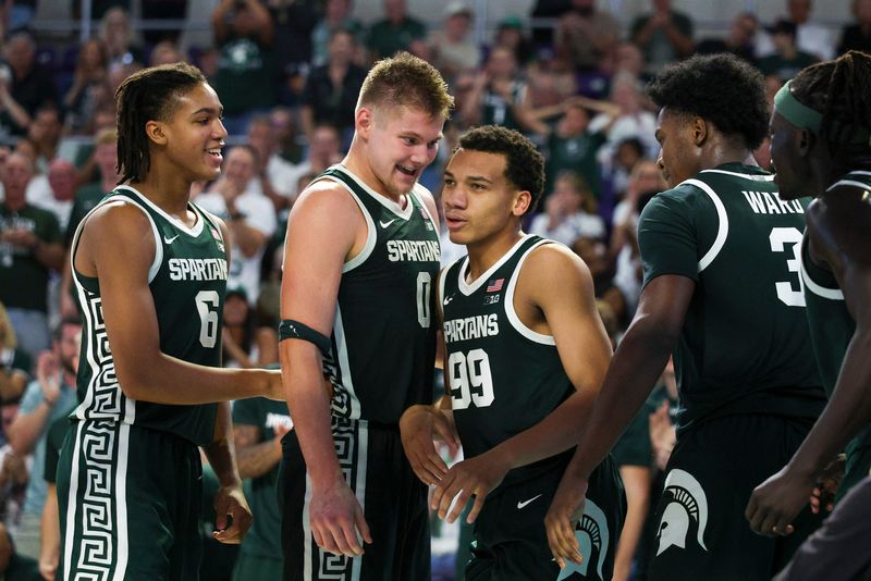 Nov 25, 2025; Fort Myers, Florida, USA; Michigan State Spartans forward Jaxon Kohler (0) and guard Divine Ugochukwu (99) react after a basket against the East Carolina Pirates in the second half at Suncoast Credit Union Arena. Mandatory Credit: Nathan Ray Seebeck-Imagn Images