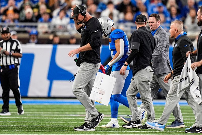 Detroit Lions head coach Dan Campbell and wide receiver Amon-Ra St. Brown (14) walks off the field due to an injury of St. Brown during the first half at Ford Field in Detroit on Thursday, Nov. 27, 2025.