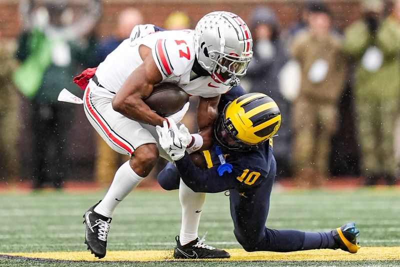Michigan defensive back Zeke Berry (10) tackles Ohio State wide receiver Carnell Tate (17) during the first half at Michigan Stadium in Ann Arbor on Saturday, Nov. 29, 2025.