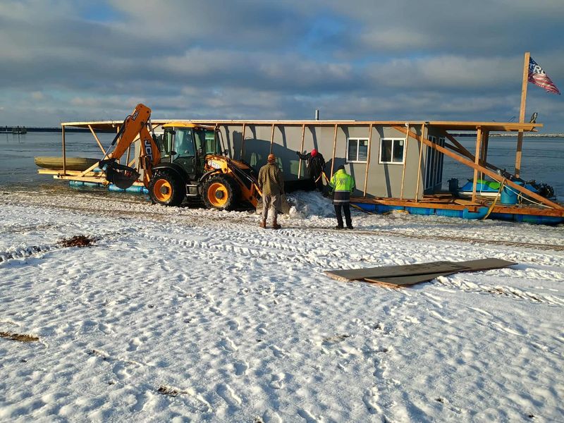 A volunteer crew attempts to bring to land the Neverlanding, a homemade Canadian houseboat, at Bird Creek Beach in Port Austin's harbor on Dec. 2, 2025.