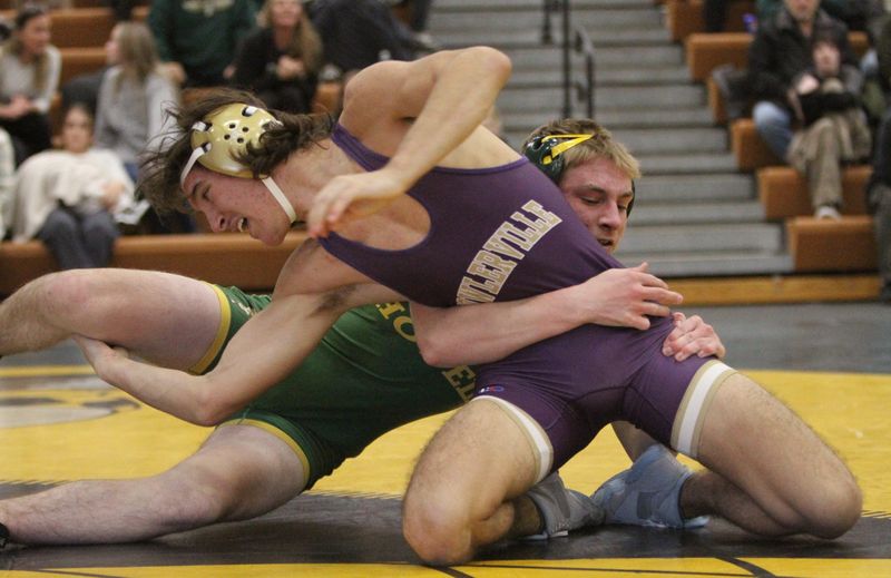 Fowlerville's Alex Loomis (foreground) wrestles Howell's Dylan Lee during a season-opening quad on Wednesday, Dec. 3, 2025 at Howell High School.