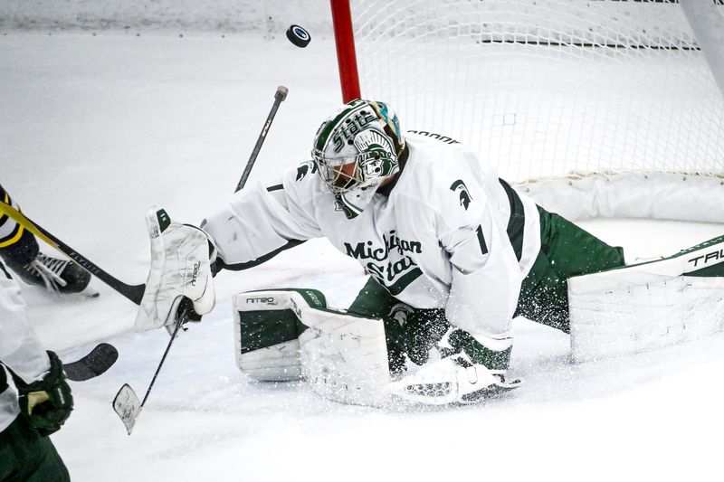 Michigan State's Trey Augustine deflects a Michigan shot during the second period on Friday, Dec. 5, 2025, at Munn Ice Arena in East Lansing.