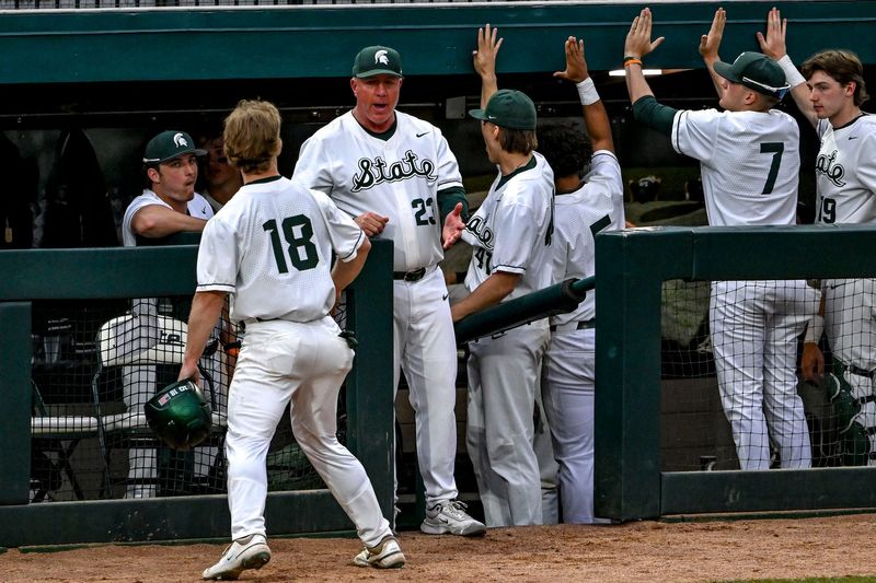Michigan State's Noah Bright, left, celebrates his score with head coach Jake Boss Jr., center, and the dugout during the eighth inning in the game against Ohio State on Friday, April 18, 2025, at McLane Stadium in East Lansing.