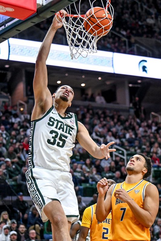 Michigan State's Jesse McCulloch, left, dunks as Toledo's Sean Craig defends during the first half on Tuesday, Dec. 16, 2025, at the Breslin Center in East Lansing.