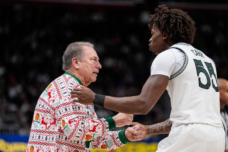 Michigan State head coach Tom Izzo talks to forward Coen Carr (55) after a play against Oakland during the second half at Little Caesars Arena in Detroit on Saturday, Dec. 20, 2025.