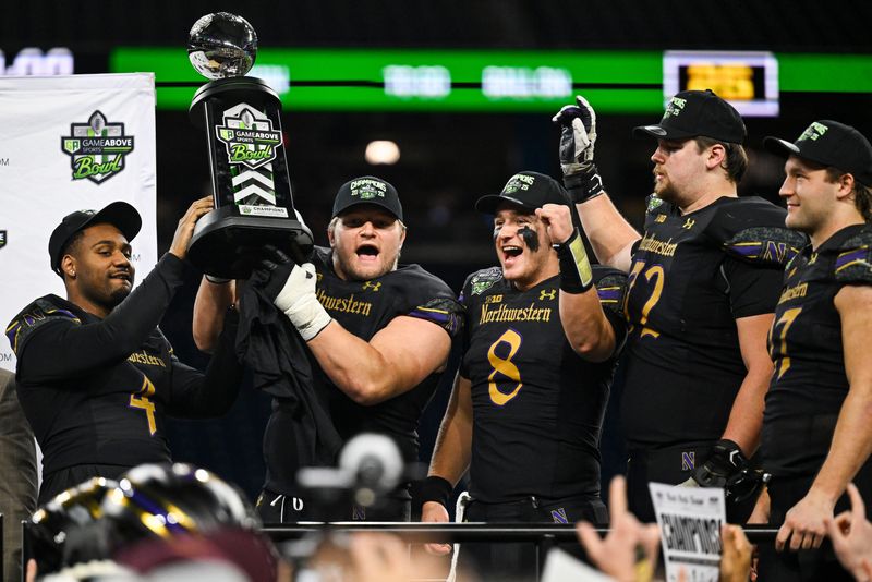 Northwestern defensive lineman Carmine Bastone, center left, and quarterback Preston Stone, center right, celebrate with their GameAbove Sports Bowl championship trophy after their 34-7 victory over Central Michigan on Friday, Dec. 26, 2025 at Ford Field in Detroit.