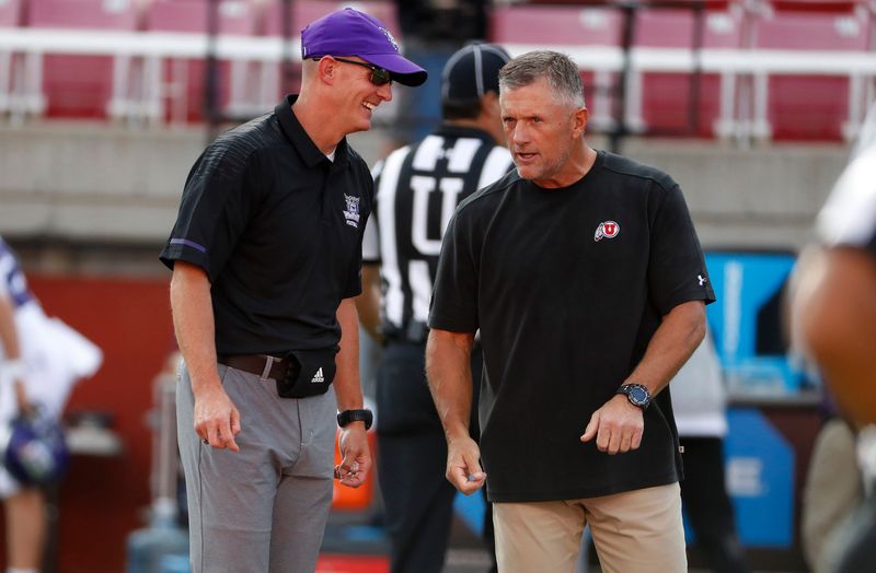 Weber State Wildcats head coach Jay Hill, left and Utah Utes head coach Kyle Whittingham get together prior to their game at Rice-Eccles Stadium in Salt Lake City on Aug. 30, 2018