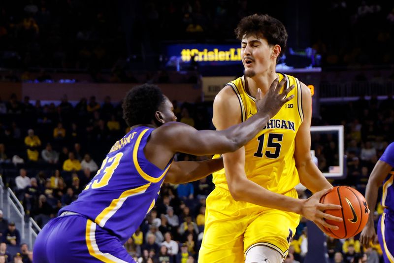Michigan Wolverines center Aday Mara (15) dribbles defended by McNeese Cowboys guard Carl Cherenfant (23) in the first half at Crisler Center in Ann Arbor on Monday, Dec. 29, 2025.