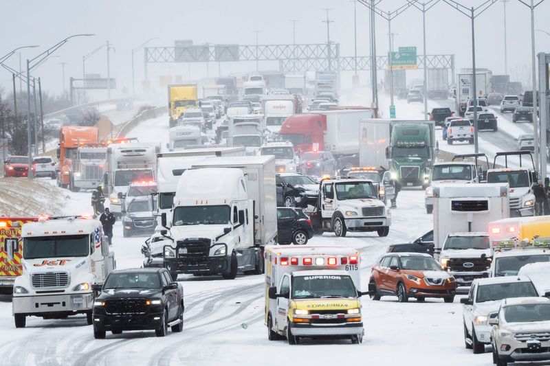 Rescue workers and tow trucks work to help people at a multiple-car pileup on northbound I-75 near Highland Park, Michigan, after snow squalls and strong winds made driving conditions dangerous on the roadways on Monday, Dec. 29, 2025.