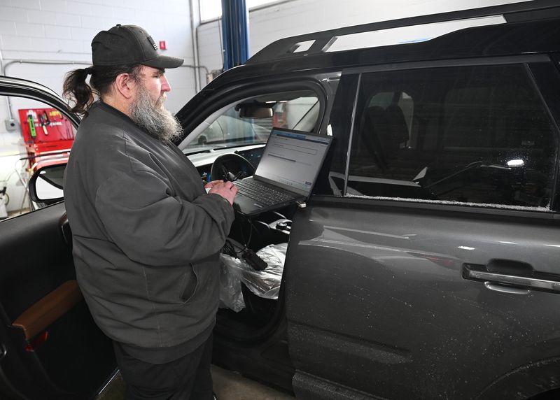 Jim Duncan, a technician at Village Ford Service Center, installs an instrument panel cluster update on a recalled 2023 Bronco Sport on Dec. 30, 2025, in Dearborn. Ford Motor Co. over the past year recalled more vehicles than the rest of the major automotive industry, according to a study from auto search engine iSeeCars.com.