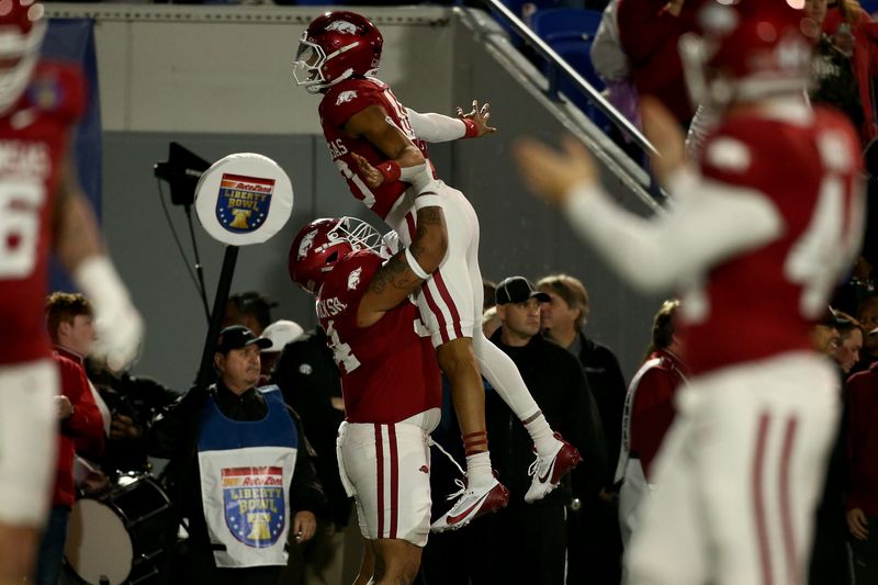 Dec 27, 2024; Memphis, TN, USA; Arkansas Razorbacks quarterback Taylen Green (10) is lifted by offensive linemen Keyshawn Blackstock (54) after a touchdown during the first quarter against the Texas Tech Red Raiders at Simmons Bank Liberty Stadium. Mandatory Credit: Petre Thomas-Imagn Images
