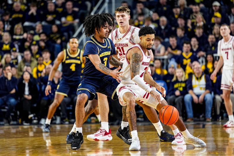 Michigan guard Elliot Cadeau (3) defends Wisconsin guard Nick Boyd (2) during the first half at Crisler Center in Ann Arbor on Saturday, Jan. 10, 2026.