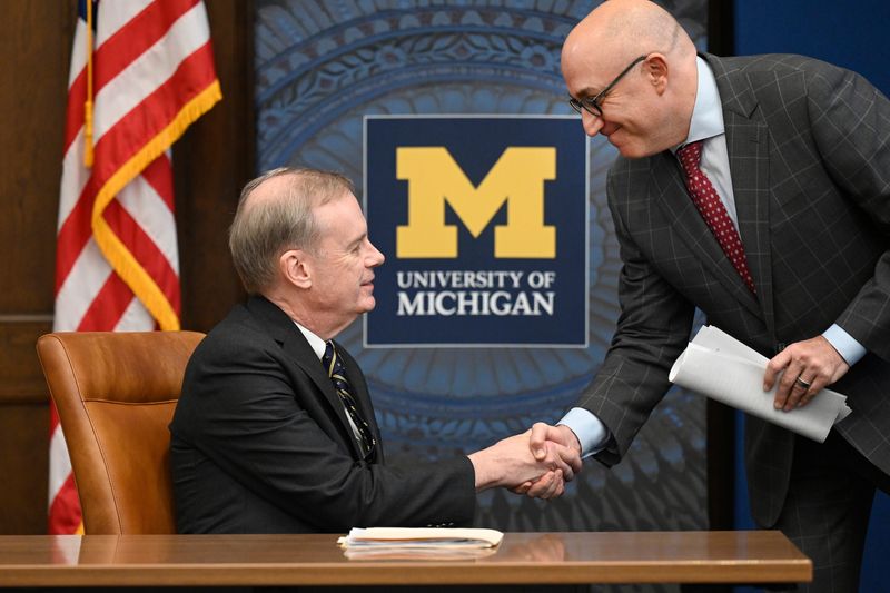 University of Michigan Regent Mark Bernstein, right, greets Kent Syverud, former chancellor of Syracuse University, before a vote to nominate Syverud as the next U of M president. Photo taken on Monday, Jan. 12, 2026, in Ann Arbor, Mich.