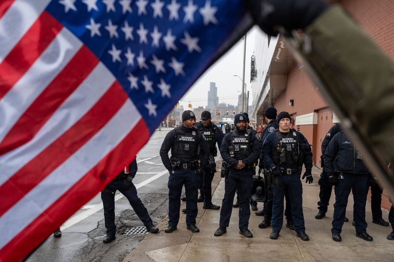 Protesters stand in front of a line of police officers during an anti-Trump protest outside the MotorCity Casino Hotel, in Detroit on Tuesday, Jan. 13, 2026.