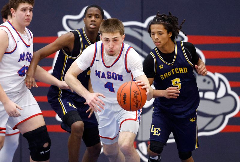 Mason's Mason Dowdy, center, pushes the ball after a steal against Lansing Eastern's Ziden Harris-Anderson, right, and Ian Curtis, Friday, Jan. 16, 2026, in Mason.