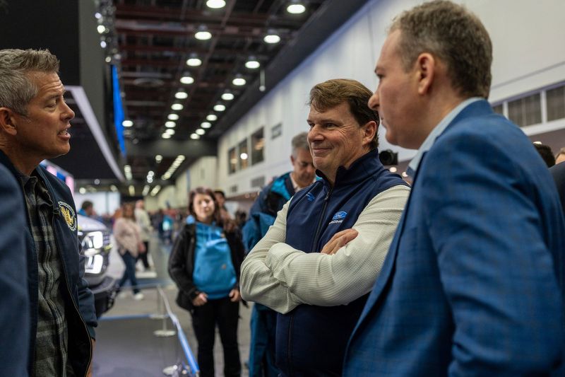 Sean Duffy, left, U.S. secretary of transportation, speaks with Jim Farley, president and CEO of Ford Motor Co., and Lee Zeldin, administrator of the U.S. Environmental Protection Agency, during the 2026 Detroit Auto Show at Huntington Place in Detroit on Saturday, Jan. 17, 2026.